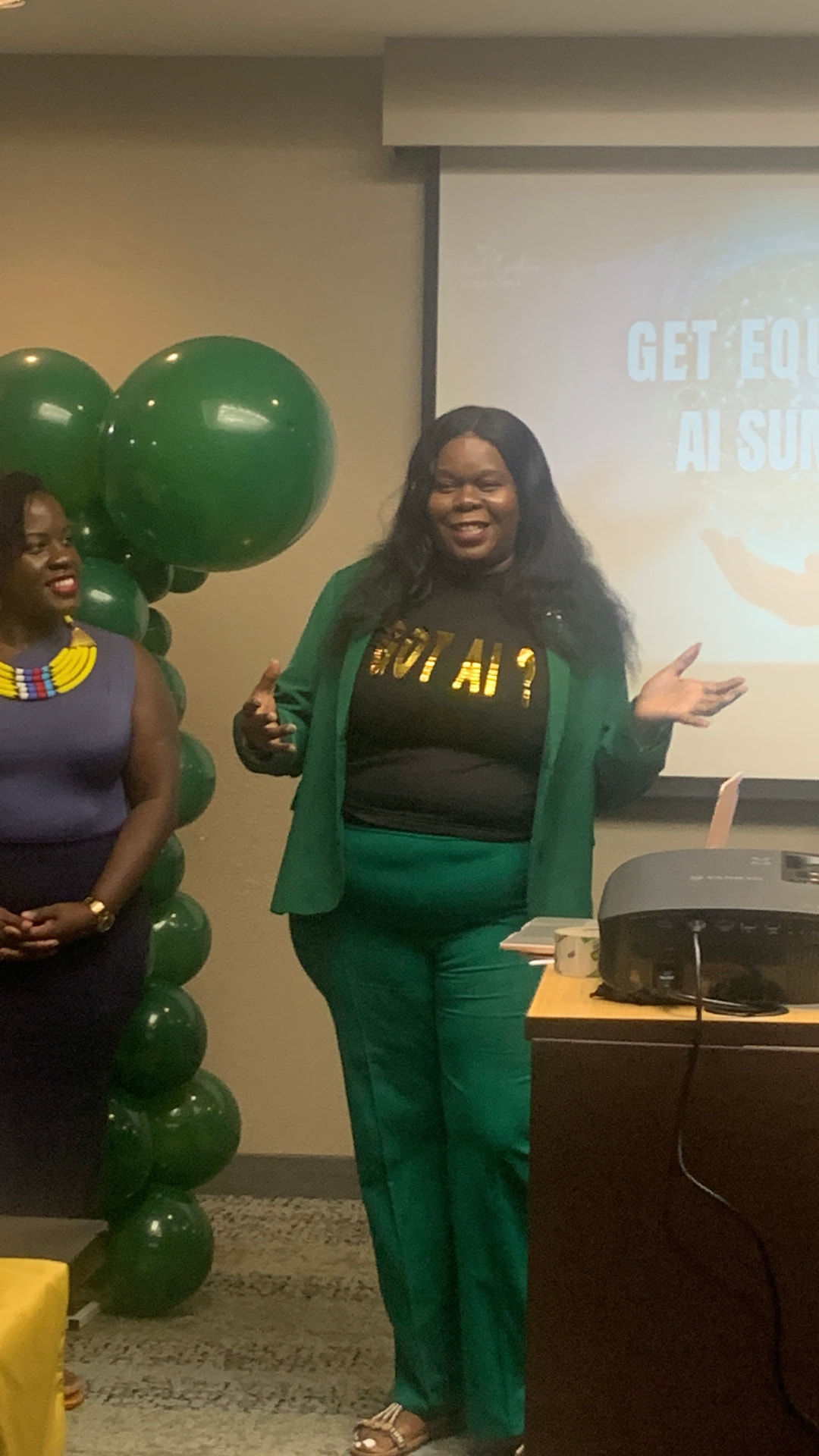 Marline Paul smiling mid-presentation at the Get Equipped AI Summit beside green balloon decor