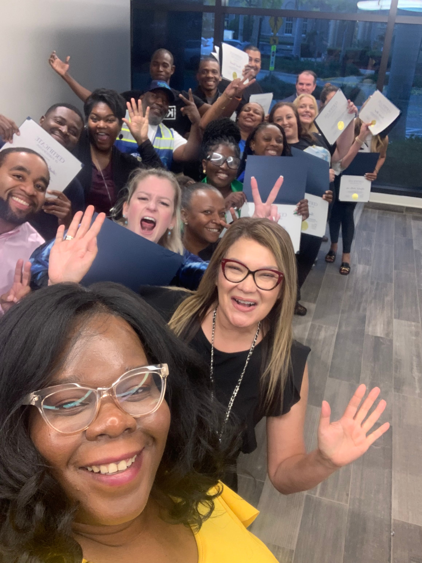 Marline Paul taking a joyful group selfie with workshop graduates holding their certificates at the City of Boynton Beach Economic Development workshop
